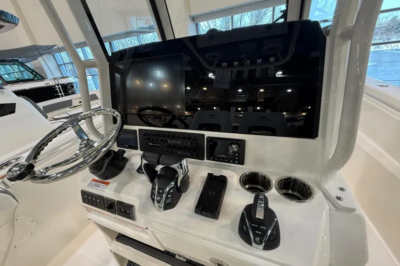 Slide: The Image of 2026 Cobia 285 Center Console helm with steering wheel, controls, and display screen. - 12
