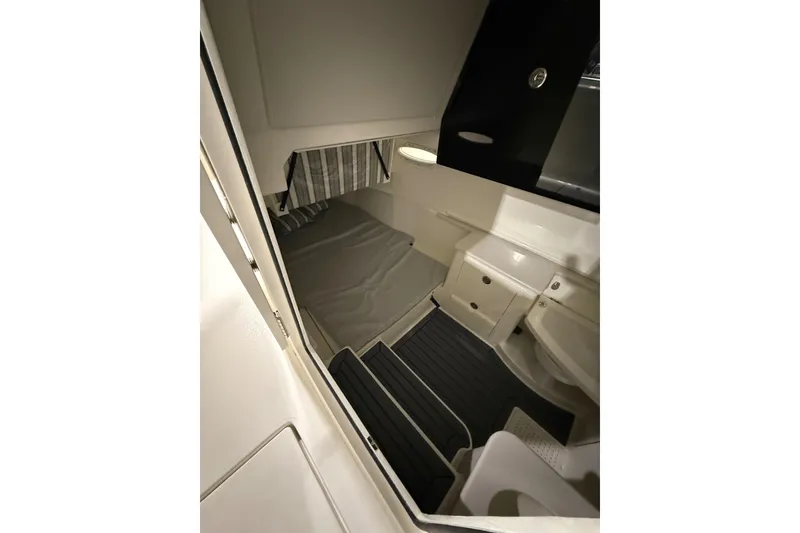 Slide: The Image of Interior cabin of 2026 Cobia 350 Center Console boat, featuring a compact sleeping area. - 14