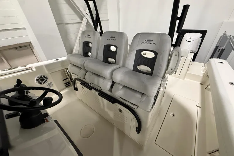 Slide: The Image of 2026 Cobia 350 Center Console boat interior with three cushioned seats and steering wheel. - 19
