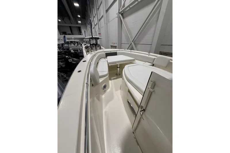 Slide: The Image of 2026 Cobia 350 Center Console boat interior with seating and table in showroom. - 26