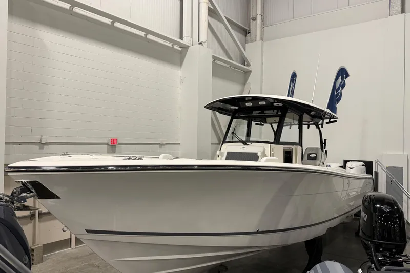Slide: The Image of 2026 Cobia 350 Center Console boat displayed indoors with dual outboard engines. - 3