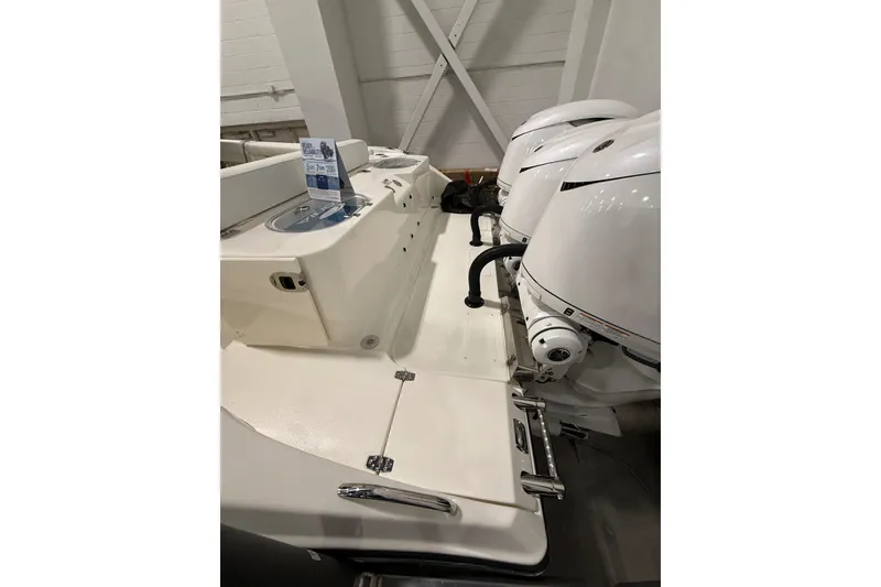 Slide: The Image of 2026 Cobia 350 Center Console boat with dual outboard engines in a showroom. - 6