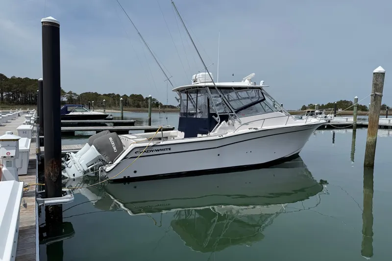 Slide: The Image of 2002 Grady-White Express 330 boat docked in a marina, calm water reflection. - 0
