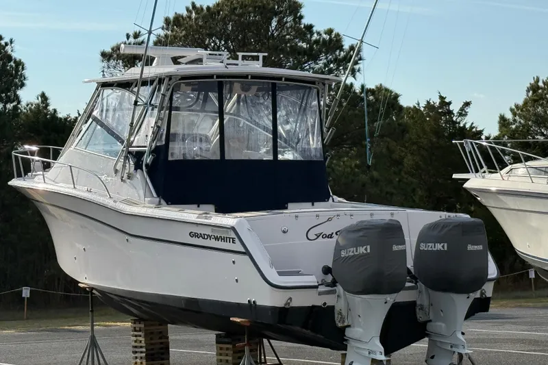 Slide: The Image of 2002 Grady-White Express 330 boat with twin Suzuki outboard motors, parked on blocks. - 1