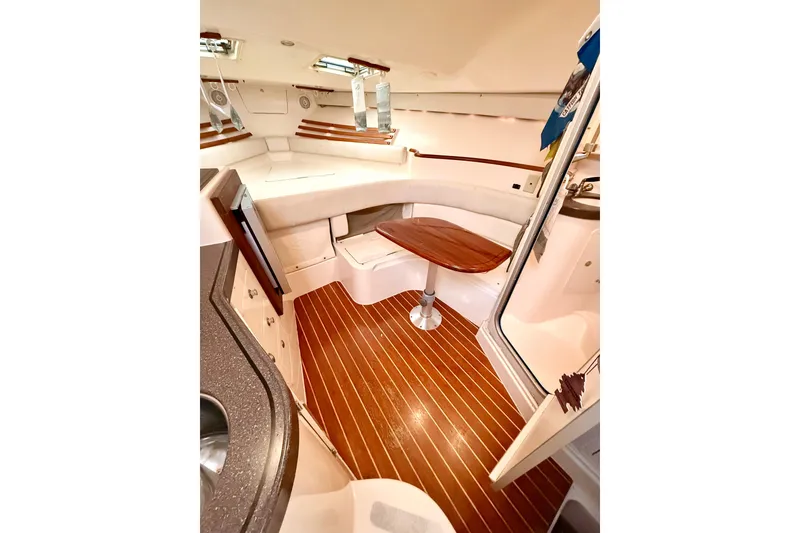 Slide: The Image of 2002 Grady-White Express 330 cabin interior with wood flooring and seating area. - 12