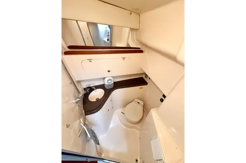 Slide: The Image of 2002 Grady-White Express 330 boat bathroom with sink, toilet, and storage cabinets. - 18