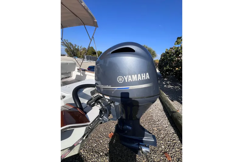 Slide: The Image of 1998 Cape Horn 23 Cape Bay with Yamaha outboard motor, parked on gravel. - 15