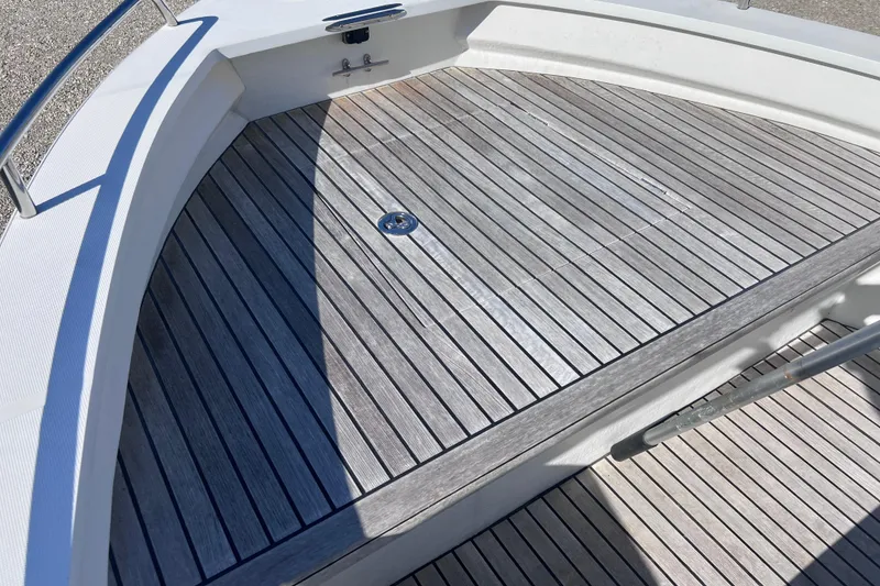 Slide: The Image of Teak deck of 1998 Cape Horn 23 Cape Bay boat, featuring sleek design and metal railing. - 19