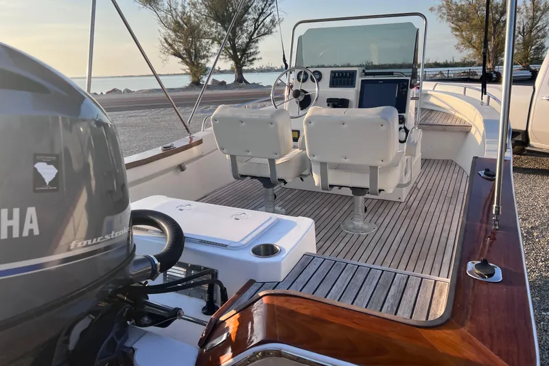 Slide: The Image of 1998 Cape Horn 23 Cape Bay boat interior with Yamaha engine, featuring dual seats and steering console. - 24