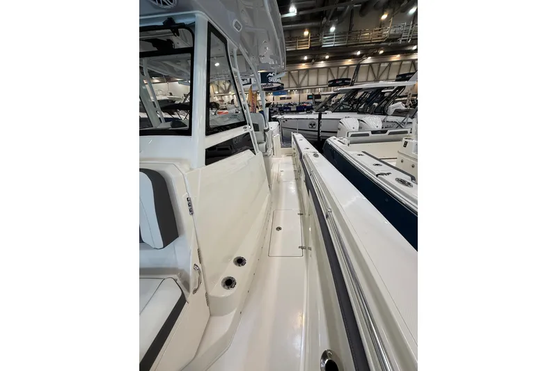 Slide: The Image of 2026 Cobia 305 Center Console boat interior at a showroom display. - 19