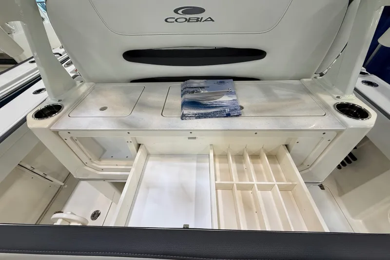 Slide: The Image of 2026 Cobia 305 Center Console boat interior with storage compartments and cup holders. - 6