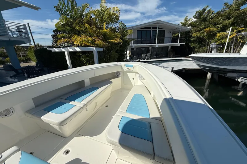 Slide: The Image of 2019 SeaVee 340Z boat with blue seating, docked near a modern waterfront house. - 7
