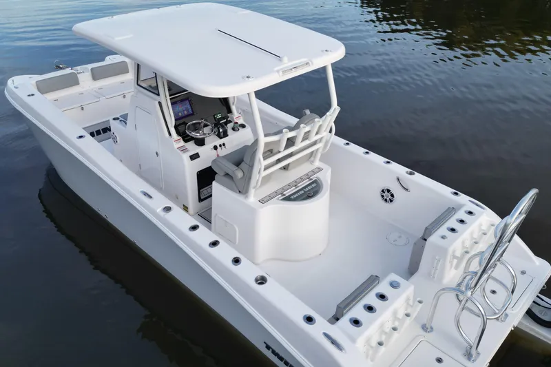 Slide: The Image of 2023 Twin Vee 260 GFX CC boat on calm water, featuring a sleek design and spacious deck. - 11