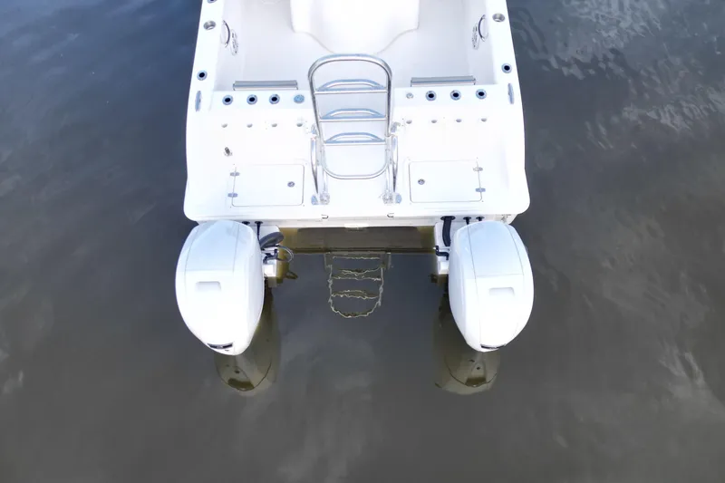 Slide: The Image of 2023 Twin Vee 260 GFX CC boat with dual outboard motors on calm water. - 15