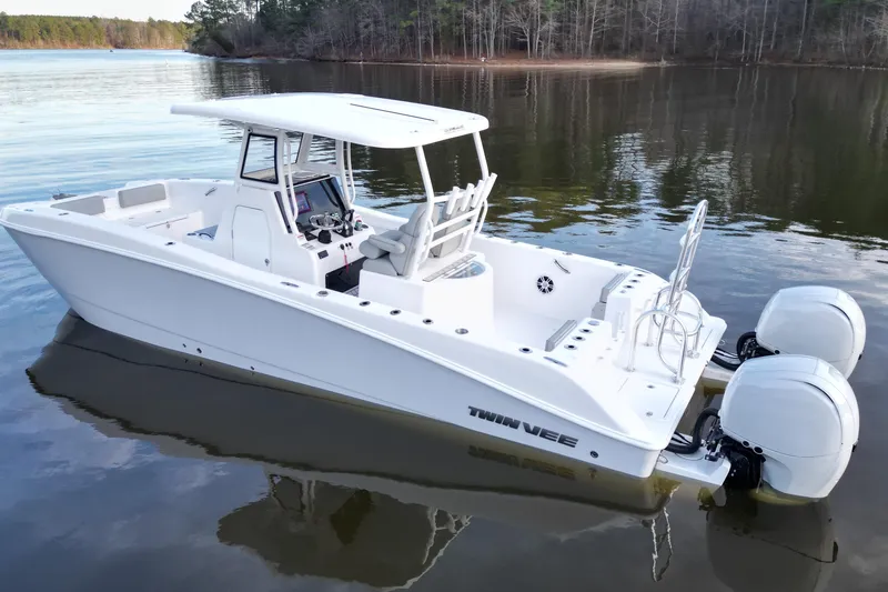 Slide: The Image of 2023 Twin Vee 260 GFX CC boat on calm lake waters, showcasing sleek design and dual engines. - 17