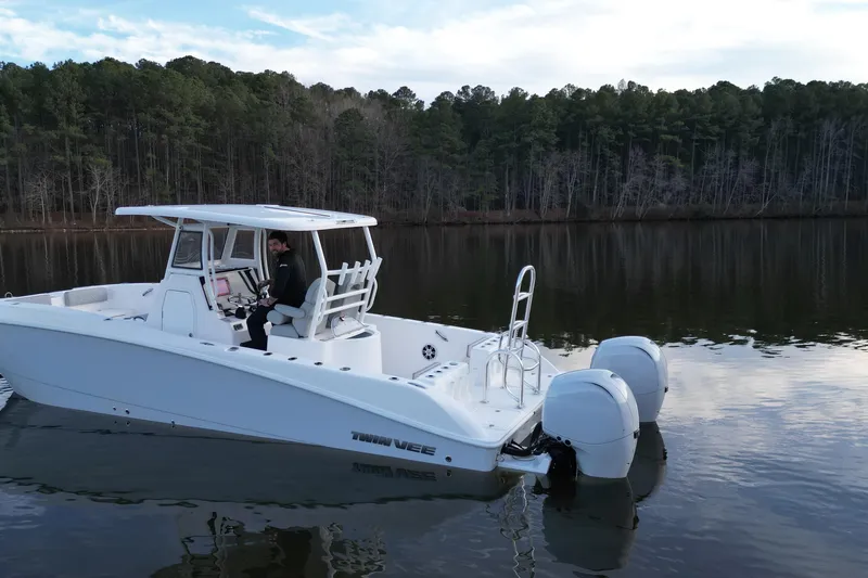 Slide: The Image of 2023 Twin Vee 260 GFX CC boat on calm lake with forest backdrop. - 29