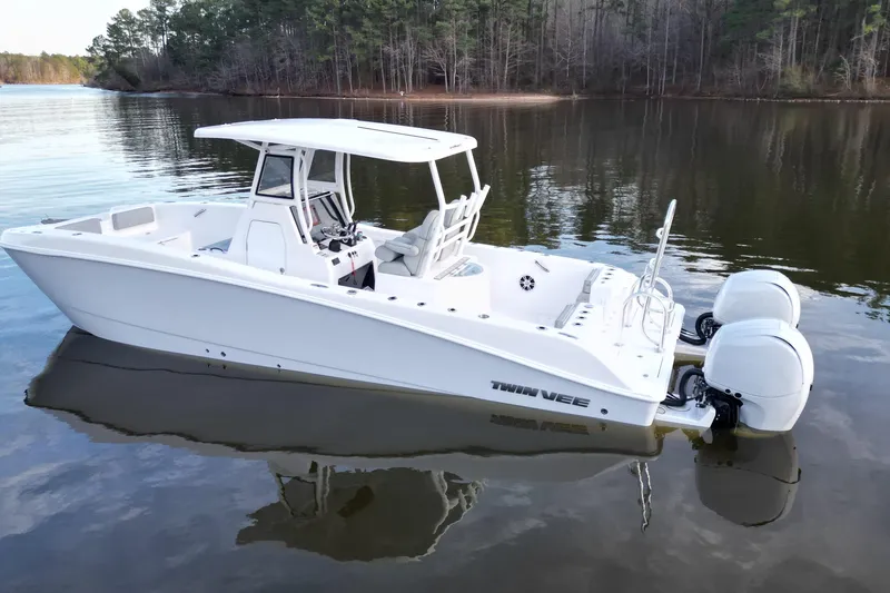Slide: The Image of 2023 Twin Vee 260 GFX CC boat on calm lake, featuring dual engines and sleek design. - 3