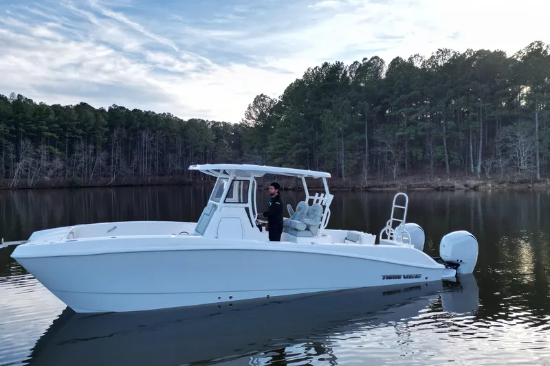 Slide: The Image of 2023 Twin Vee 260 GFX CC boat on calm lake with forested background. - 30