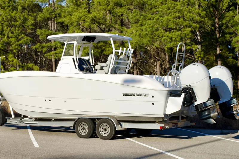 Slide: The Image of 2023 Twin Vee 260 GFX CC boat on trailer, parked in wooded area. - 33