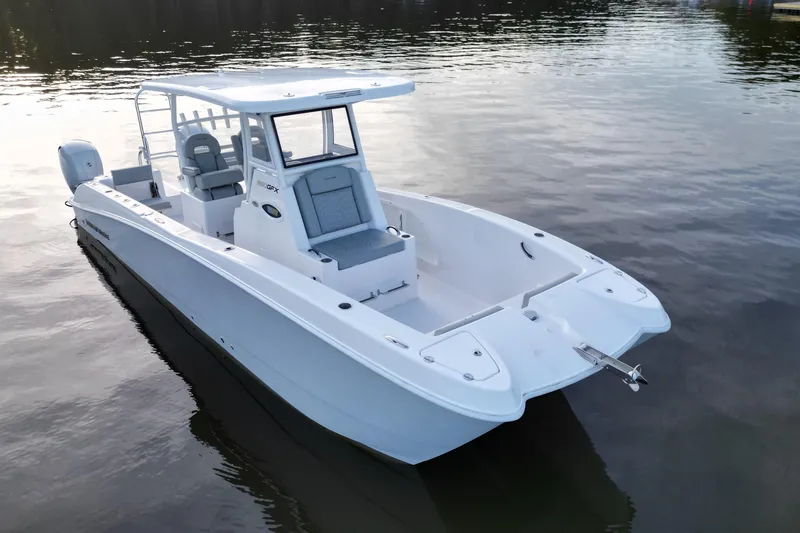 Slide: The Image of 2023 Twin Vee 260 GFX CC boat on calm water, showcasing sleek design and spacious deck. - 6