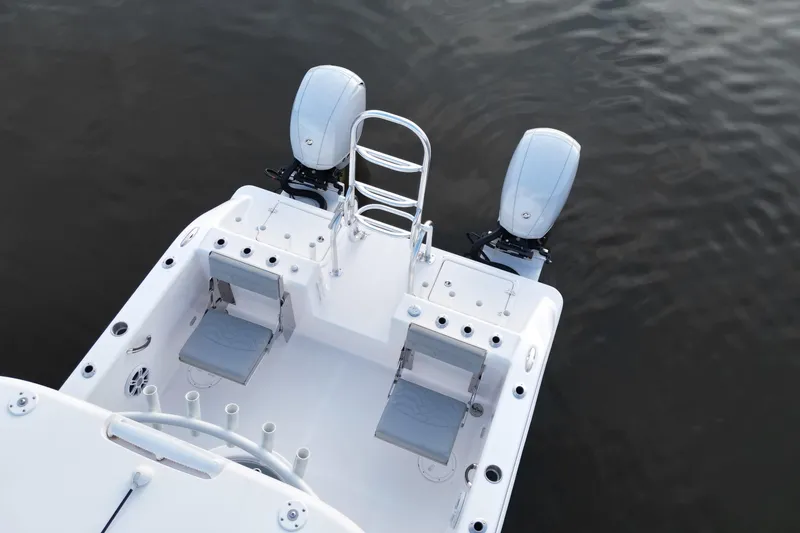 Slide: The Image of 2023 Twin Vee 260 GFX CC boat with dual engines and seating, on calm water. - 7