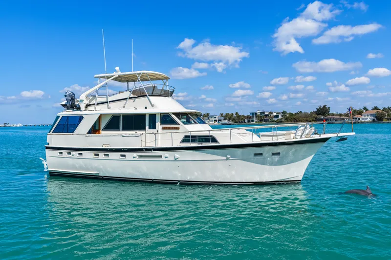 Slide: The Image of 1979 Hatteras 53 Motor Yacht on clear blue water with dolphin nearby. - 14