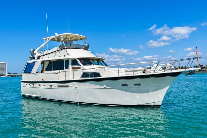 Slide: The Image of 1979 Hatteras 53 Motor Yacht cruising on clear blue water under a sunny sky. - 15