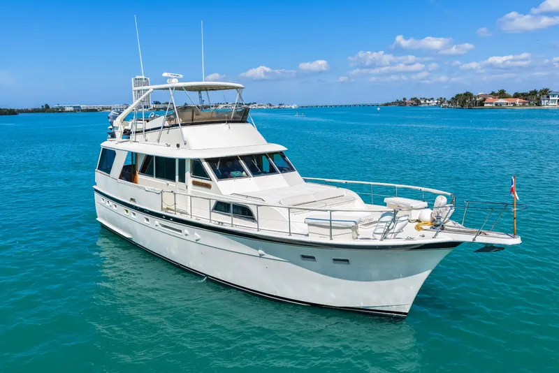 Slide: The Image of 1979 Hatteras 53 Motor Yacht cruising on clear blue waters under a sunny sky. - 16