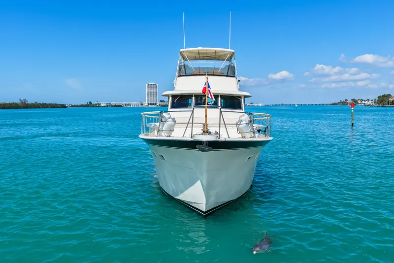 Slide: The Image of 1979 Hatteras 53 Motor Yacht on clear blue water with dolphin nearby. - 19