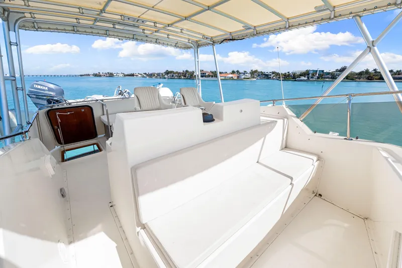 Slide: The Image of 1979 Hatteras 53 Motor Yacht deck with seating, overlooking serene blue waters. - 31