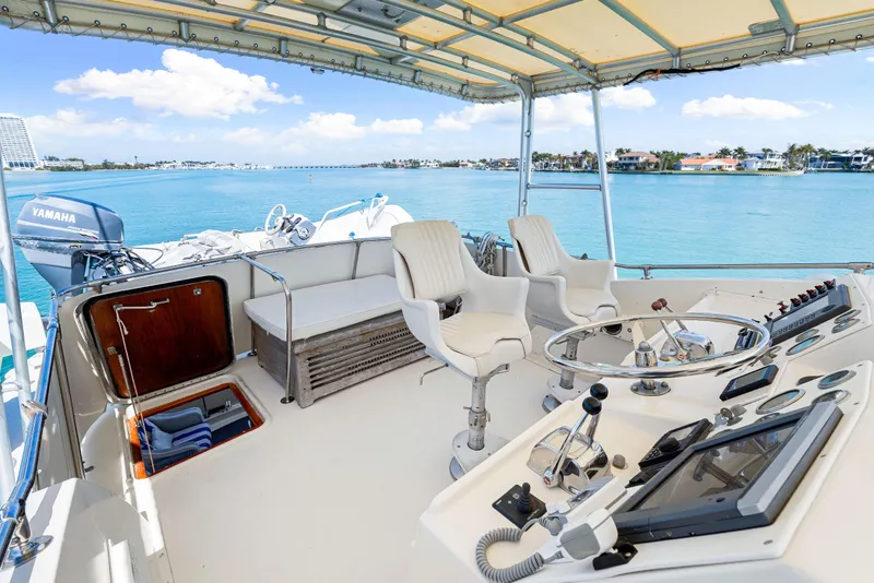 Slide: The Image of 1979 Hatteras 53 Motor Yacht helm with ocean view, featuring controls and seating. - 32