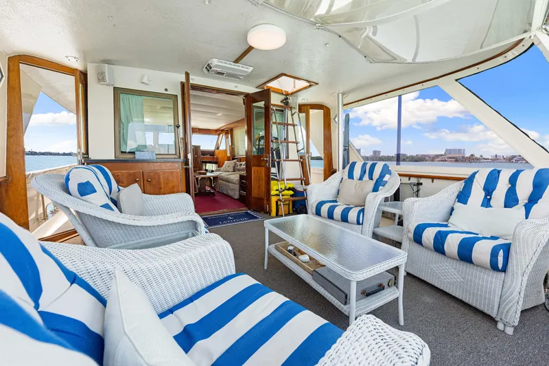 Slide: The Image of 1979 Hatteras 53 Motor Yacht interior with striped seating, ocean view, and elegant decor. - 36