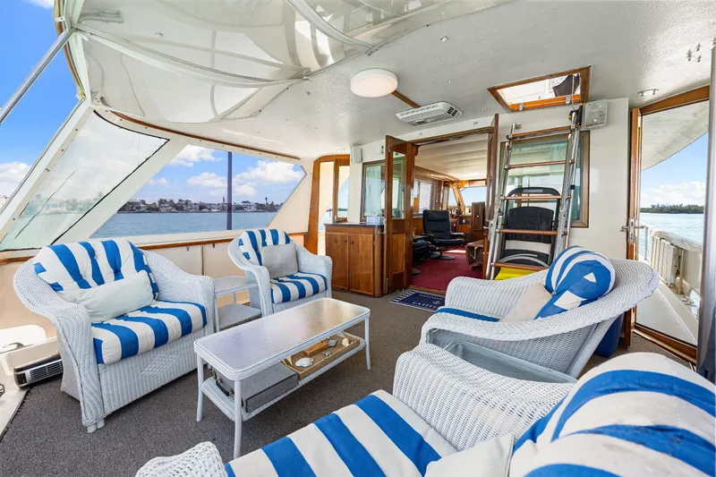 Slide: The Image of 1979 Hatteras 53 Motor Yacht interior with striped seating and ocean view. - 37