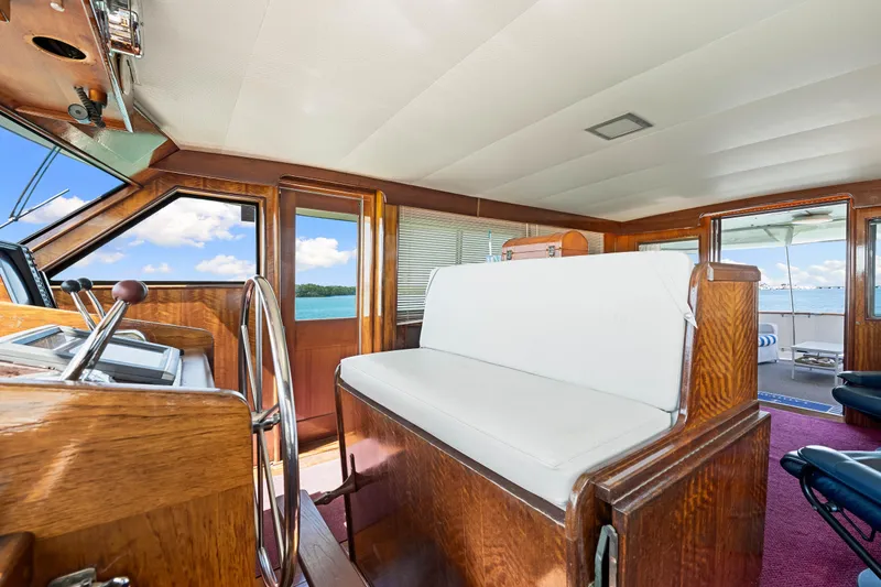 Slide: The Image of 1979 Hatteras 53 Motor Yacht interior with wooden helm and white seating, ocean view. - 46