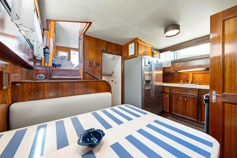 Slide: The Image of 1979 Hatteras 53 Motor Yacht interior with wood paneling and modern kitchen amenities. - 50