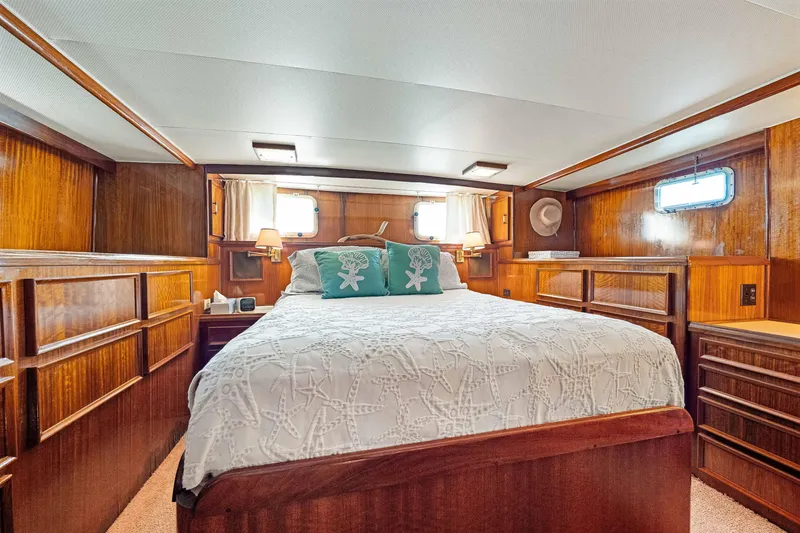 Slide: The Image of Luxurious 1979 Hatteras 53 Motor Yacht bedroom with elegant wood paneling and cozy bedding. - 52