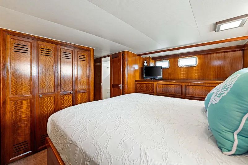 Slide: The Image of Luxurious cabin interior of 1979 Hatteras 53 Motor Yacht with wood paneling and cozy bedding. - 54