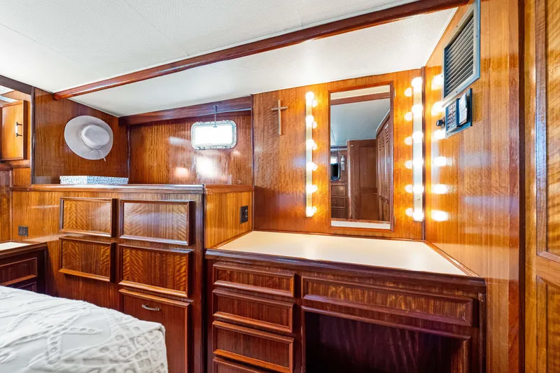 Slide: The Image of Luxurious 1979 Hatteras 53 Motor Yacht interior with wood cabinetry and vanity mirror lighting. - 55