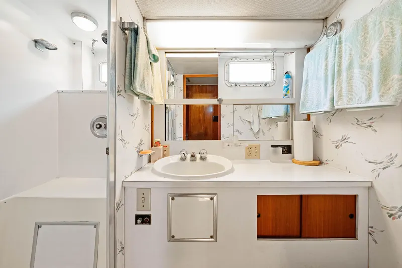 Slide: The Image of 1979 Hatteras 53 Motor Yacht bathroom with sink, mirror, and shower area. - 56