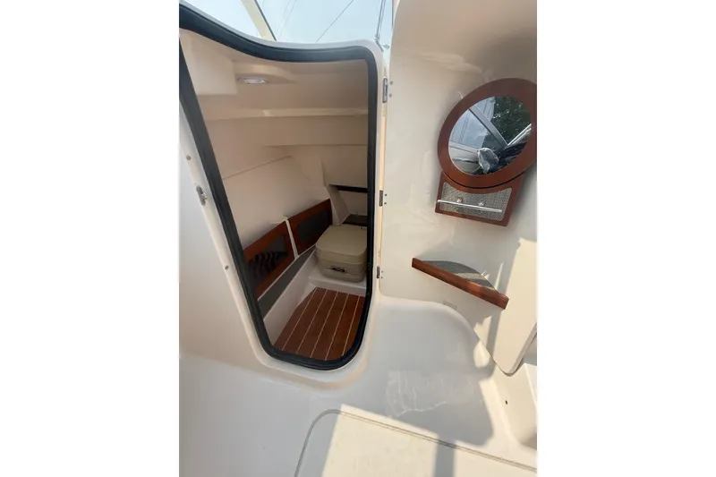Slide: The Image of 2017 Grady-White Freedom 235 cabin interior with seating and mirror. - 28