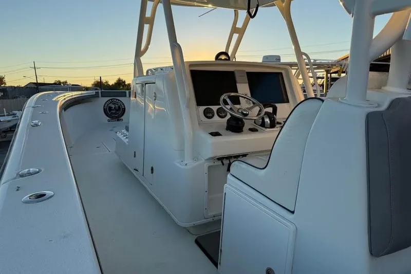 Slide: The Image of 2015 Yellowfin 39 Offshore boat interior with helm and seating at sunset. - 3
