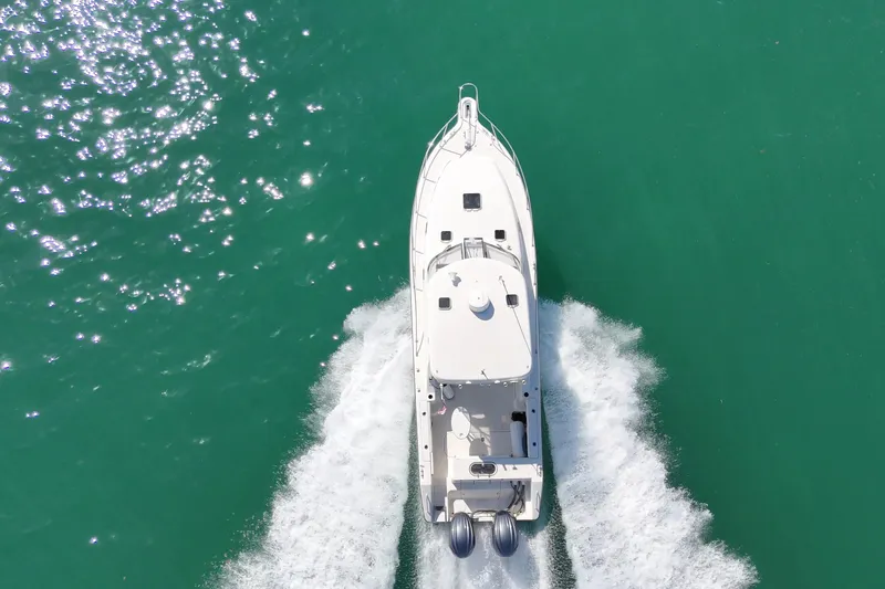 Slide: The Image of Aerial view of 2004 Pursuit 3370 Offshore boat cruising on turquoise water. - 10