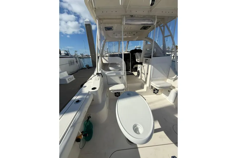 Slide: The Image of 2004 Pursuit 3370 Offshore boat interior with seating and helm, docked at marina. - 15
