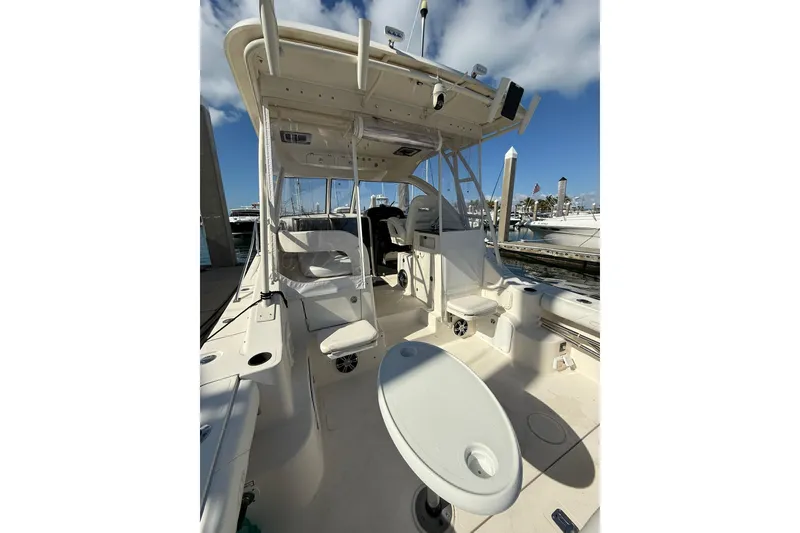 Slide: The Image of 2004 Pursuit 3370 Offshore boat interior with seating and helm, docked at marina. - 16