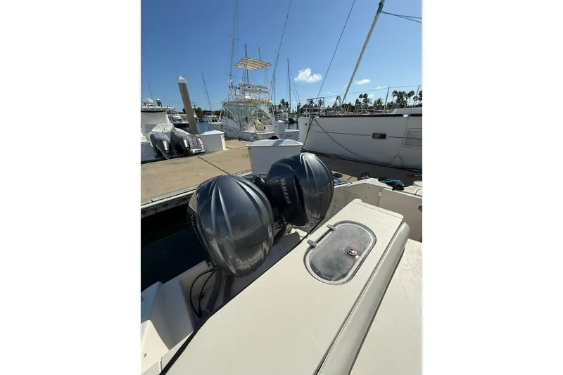 Slide: The Image of 2004 Pursuit 3370 Offshore boat with dual Yamaha engines docked at marina. - 19