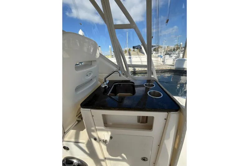 Slide: The Image of 2004 Pursuit 3370 Offshore boat interior with sink and cup holders. - 27