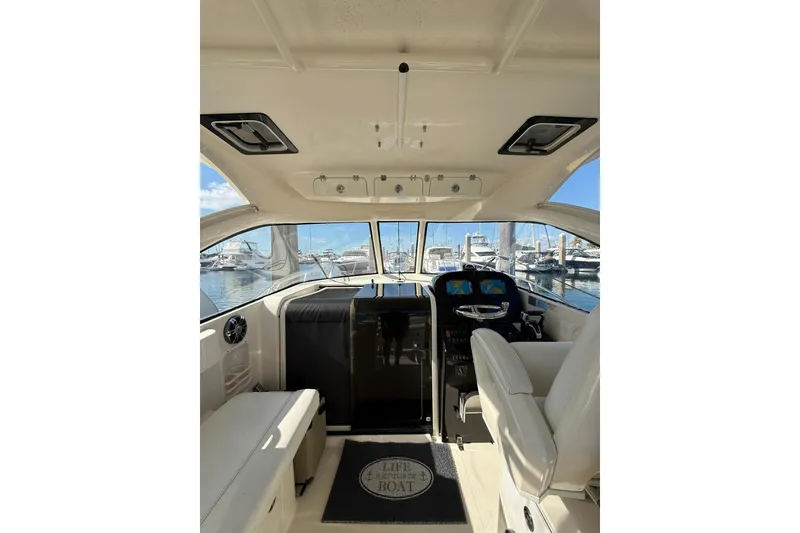 Slide: The Image of 2004 Pursuit 3370 Offshore boat interior with helm, seating, and marina view. - 28