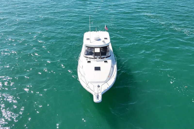 Slide: The Image of 2004 Pursuit 3370 Offshore boat on clear turquoise water, aerial view. - 3