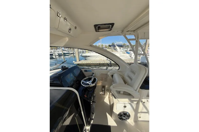 Slide: The Image of 2004 Pursuit 3370 Offshore boat interior with helm and seating at marina. - 30