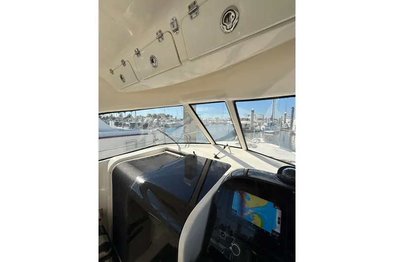 Slide: The Image of 2004 Pursuit 3370 Offshore boat interior with navigation system and marina view. - 33